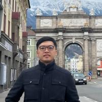 Jonathan Wong standing on a city street in front of a monument