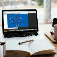 Image showing IQmol interface on a laptop in front of a notebook